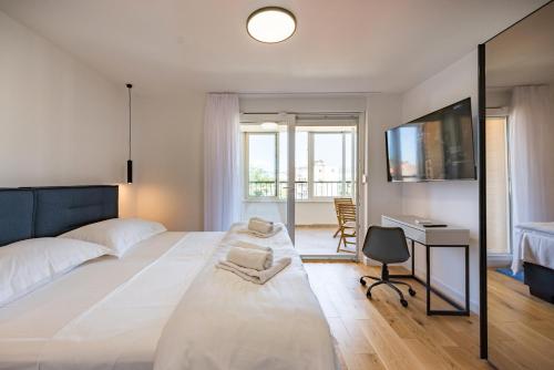 a bedroom with a bed with a desk and a television at Penthouse with view in city center in Split