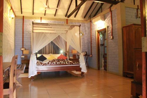 a bedroom with a bed with a canopy at Lake Serenity Resort & Spa in Kuruwita