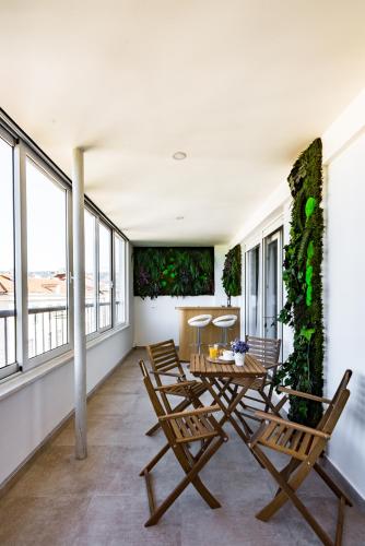 a dining room with a table and chairs and windows at Penthouse with view in city center in Split