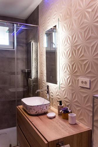 a bathroom with a bowl sink on a wooden counter at Penthouse with view in city center in Split