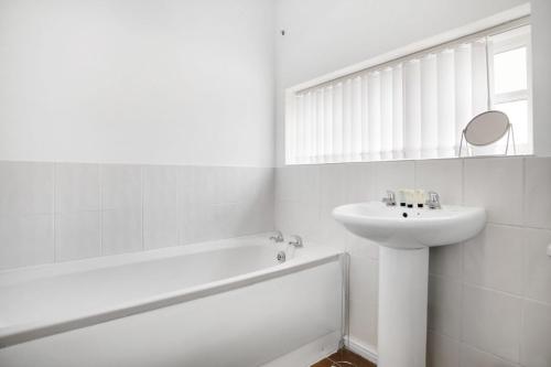 a white bathroom with a sink and a bath tub at Stylish Comfort 2-BedFlat In Stockton, Sleeps 3 in Stockton-on-Tees