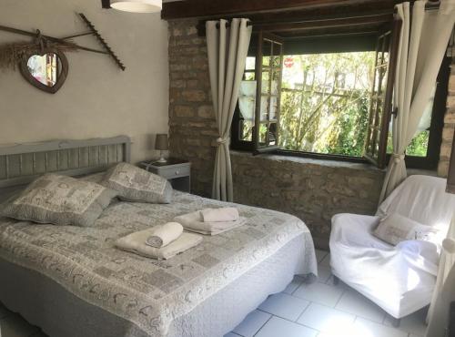 1 dormitorio con 1 cama con toallas en Le jardin d'Eden, en Valojoulx