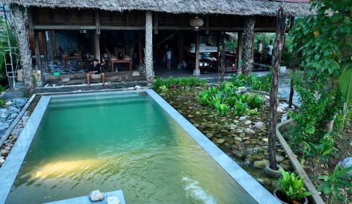 uma piscina de água em frente a uma casa em Thavill Retreat HaGiang em Ha Giang