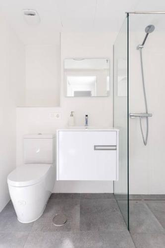 a white bathroom with a toilet and a shower at Marejada Coastal Suite in Puertito de Güímar