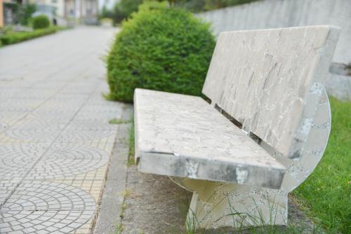 a stone bench sitting on the side of a sidewalk at Village of Peace - House 38 in Shkodër