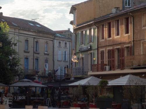 a group of buildings with tables and umbrellas at KYRIAD ORANGE Centre Ville - HOTEL & RESTAURANT & BAR - La Galerie d'Art des Princes - Provence Alpes Côte d'Azur - France - Proche A7-A9 - exit21- Châteauneuf-du-Pape Avignon Bollene Nimes - 24h-24h in Orange