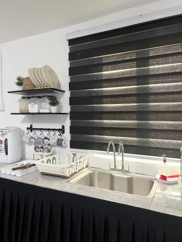 a kitchen counter with a sink and a microwave at Modern Style Village House in Kuching