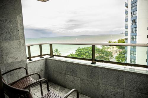 uma varanda com cadeiras e vista para a praia em Nobile Residences Maria Frazão em Recife