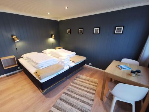 1 dormitorio con cama, mesa y escritorio en Panoramic seaview cabin for two persons by the sea, en Hovdan