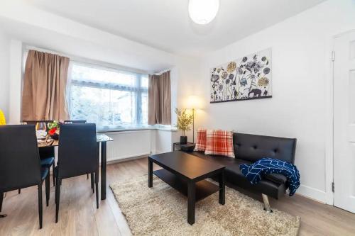 a living room with a table and a dining room at 2-Bedroom Apartment in Greater London: Explore and Relax in Enfield