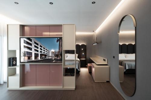 una camera con letto, specchio e lavandino di La Suite Matera Hotel & Spa a Matera
