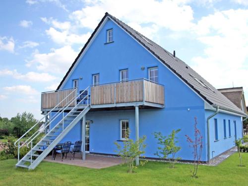 une maison bleue avec une terrasse couverte et une terrasse dans l'établissement Holiday Home Blu Hus, à Freest