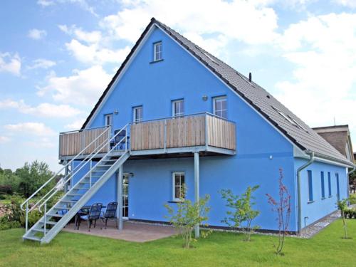 een blauw huis met een veranda en een terras bij Holiday Home Blu Hus in Freest