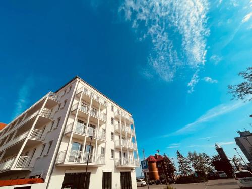 a white building in front of a blue sky at Apartament Marina View in Darłowo