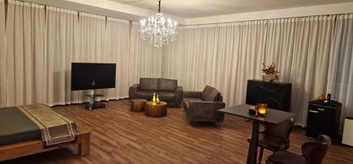 a living room with a couch and a television at Privat-Spa mit Whirlpool und Sauna in Sursee in Sursee