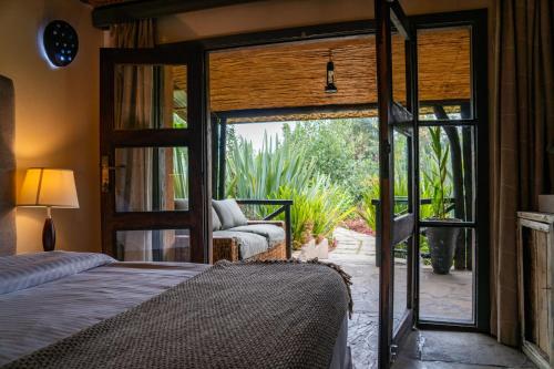 a bedroom with a bed and a sliding glass door at Sambora Kinigi in Kinigi