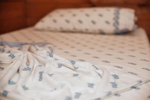 a bed with blue and white sheets and a pillow at Village of Peace - House 38 in Shkodër