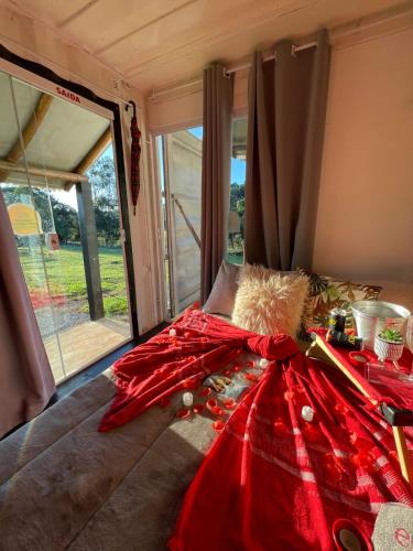 a red bow on top of a bed with a window at Ecaffe Hotel Pousada Container - Coqueiral MG in Coqueiral