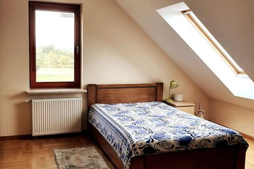 Schlafzimmer mit einem Bett und einem Fenster in der Unterkunft Ducka Wola 10 - Cichy Zakątek, sielanka na wsi in Stromiec