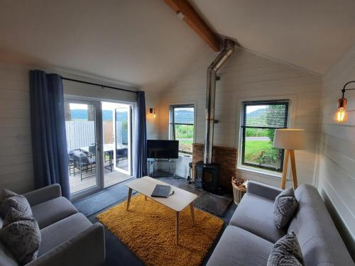 ein Wohnzimmer mit einem Sofa und einem Tisch in der Unterkunft Kinnaird Woodland Lodges in Pitlochry