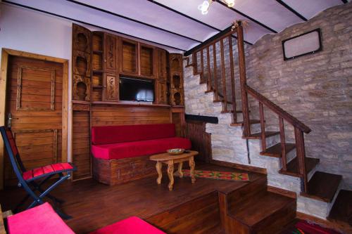 uma sala de estar com um sofá vermelho e escadas em Duplex Apartment KANDILE em Gjirokastër