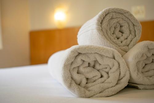 a pile of towels sitting on top of a bed at Hotel Fazenda M1 in Águas de Lindóia