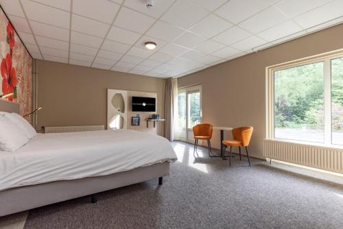 a bedroom with a bed and a table and chairs at Fletcher Hotel-Restaurant De Scheperskamp in Lochem