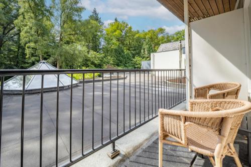 a balcony with two chairs and a fence at Fletcher Hotel-Restaurant De Scheperskamp in Lochem