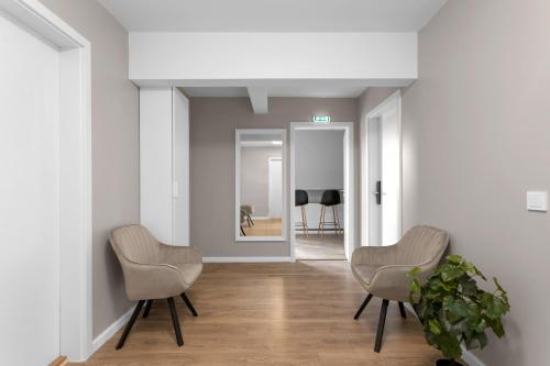 a hallway with two chairs and a mirror at Reykjavík Central Guesthouse in Reykjavík