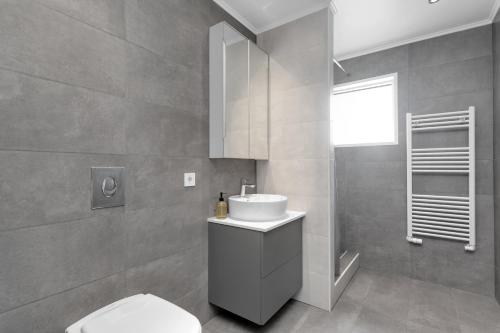 a bathroom with a white toilet and a sink at Reykjavík Central Guesthouse in Reykjavík