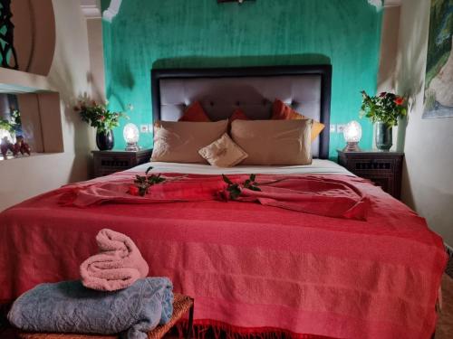 sypialnia z dużym łóżkiem i czerwonym kocem w obiekcie Casa del Sol Marrakech w Marakeszu