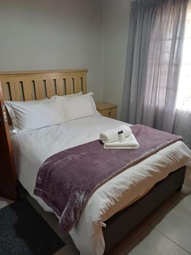a bedroom with a bed with a robe on it at Augrabies De Oude Stoor Guesthouse in Augrabies