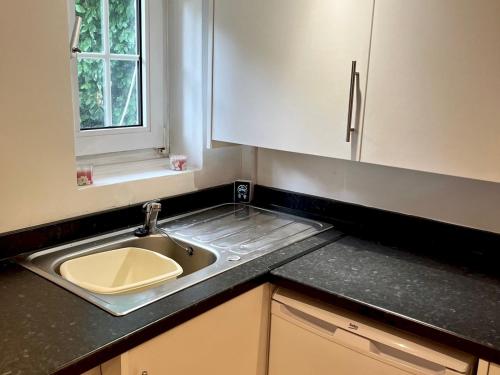 a kitchen counter with a sink and a window at Pass the Keys Cosy one bed flat with parking and scenic views in Rickmansworth