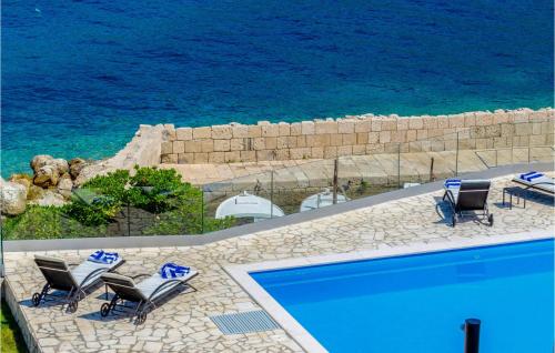 a swimming pool with chairs and a view of the ocean at Villa Gabriela Korcula in Korčula