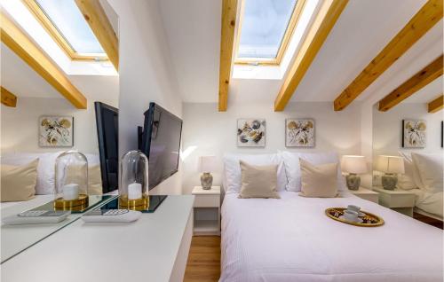 - une chambre avec un grand lit blanc et des lucarnes dans l'établissement Villa Ambar, à Škabrnje