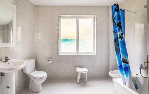 een badkamer met een toilet, een wastafel en een raam bij Beautiful Apartment In Muros With Kitchen in Muros