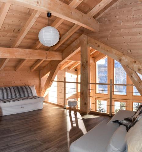 un salon avec un canapé dans un bâtiment en bois dans l'établissement Chalet Loan, à Montgenèvre