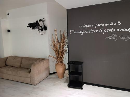 a living room with a couch and a camera on a wall at LuxHoliday Apartment in Carpignano Salentino