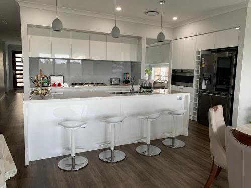 a kitchen with a white counter and stools at 7 Aurora Ave Dunmore in Dunmore