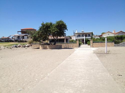 a walkway on a beach with houses in the background at Amaryllis Beach House in Lardos
