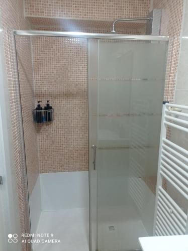 a shower with a glass door in a bathroom at Zapaterías in León