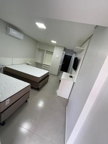 a room with two beds and a flat screen tv at GARVEY PARK in Brasilia