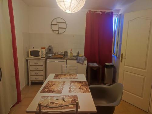 a kitchen with a table and a red curtain at Ingrid Mary in Nîmes