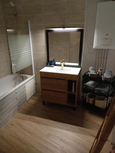 une salle de bain avec un lavabo, un miroir et une baignoire dans l'établissement La Belle Armentières, maison triplex cosy proche de Lille, à Armentières