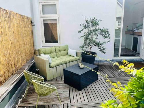 a living room with a couch and a table on a patio at Heerlijk appartement Centrum Breda en restaurant! in Breda