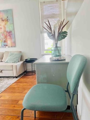 a green chair in a living room with a couch at Heerlijk appartement Centrum Breda en restaurant! in Breda