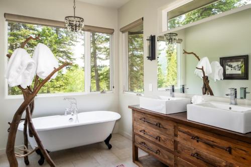 a bathroom with two sinks and a large window at Gray Owl Retreat in Big Sky