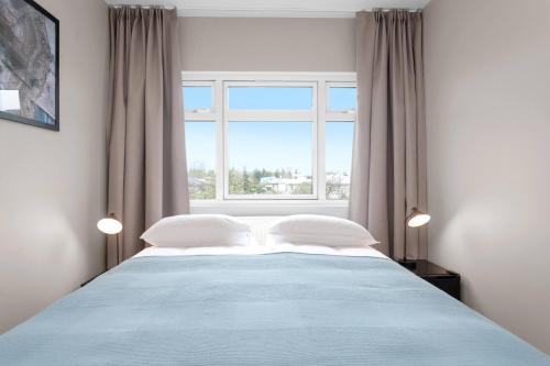 een slaapkamer met een groot bed en een raam bij Reykjavík Central Guesthouse in Reykjavík