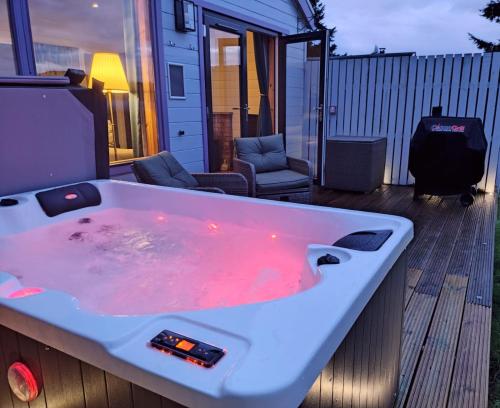 a bath tub with red liquid in it on a deck at Kinnaird Woodland Lodges in Pitlochry