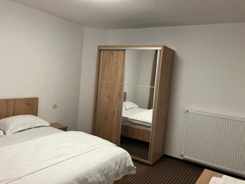a bedroom with a mirror next to a bed at PENSIUNEA KONFORT in Borsa